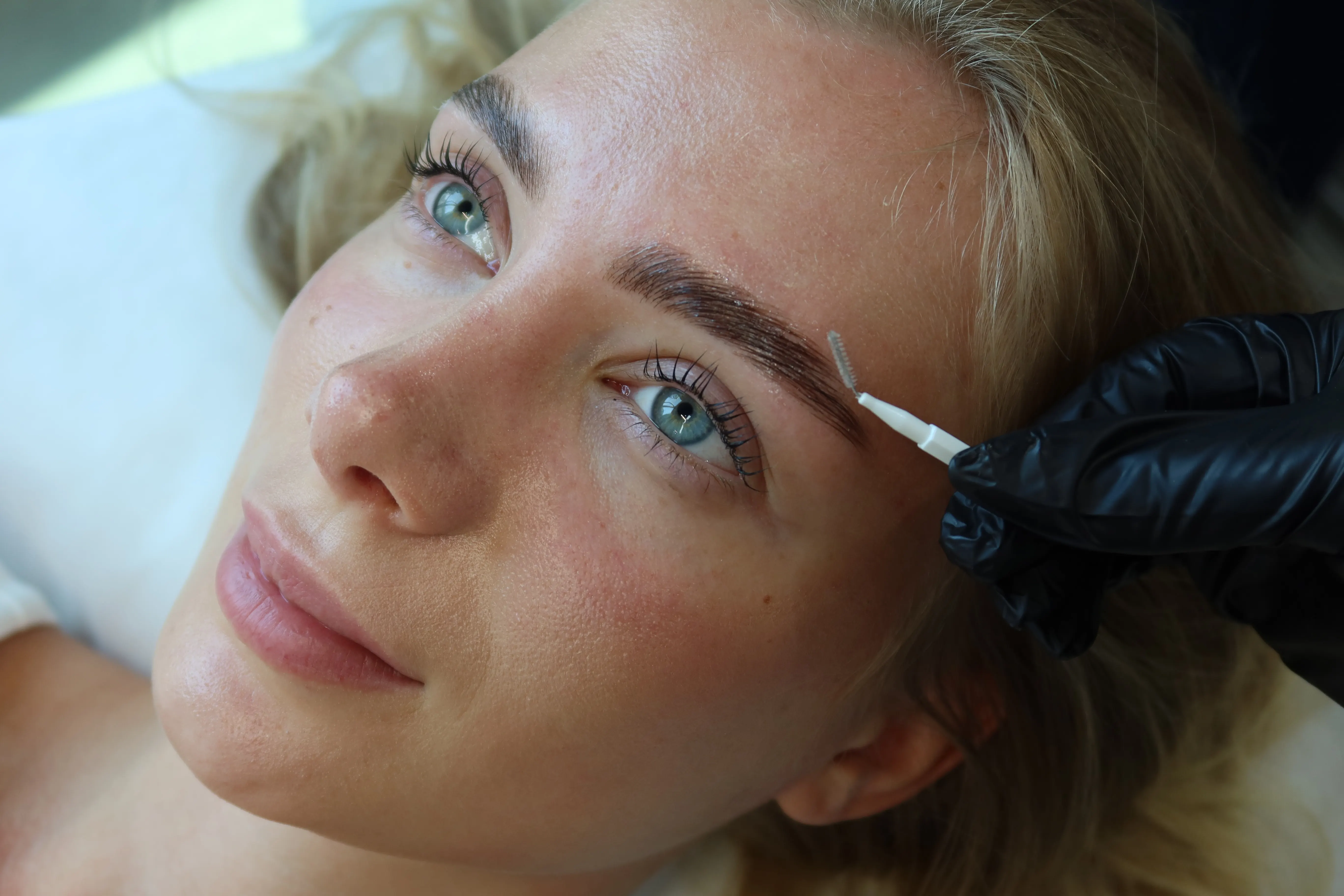 Brow shaping treatment in progress at Azizam